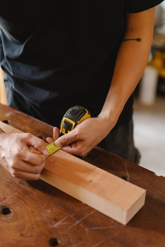 Crop artisan measuring width of plank